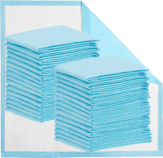 Stacked disposable blue underpads on a quilted white background, medical absorbent pads
