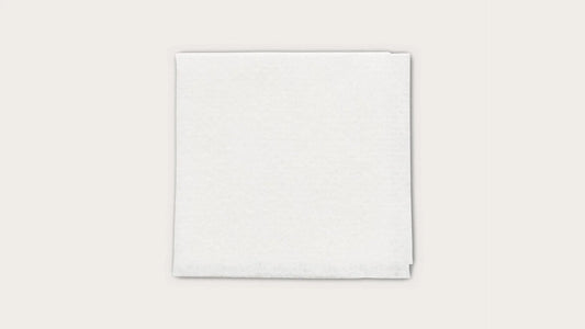 Sterile white medical gauze pad on a plain background