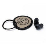 Stethoscope replacement parts kit with diaphragm, eartips, and rubber ring on white background.