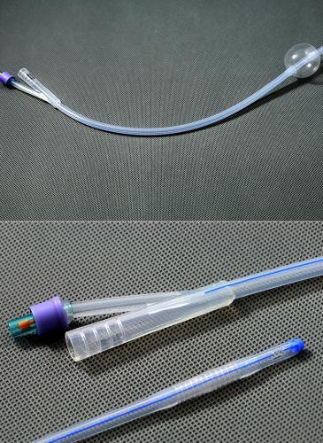 Sterile silicone Foley catheter with balloon, detailed view on textured background, medical supplies.