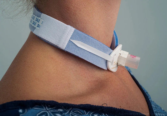 Close-up of person wearing a medical tracheostomy tube holder on neck