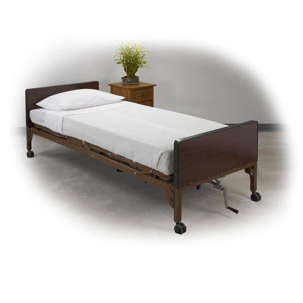 Hospital bed with white sheets, wooden headboard, and caster wheels in a healthcare room