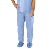 Person wearing light blue disposable medical scrubs and shoe covers on white background