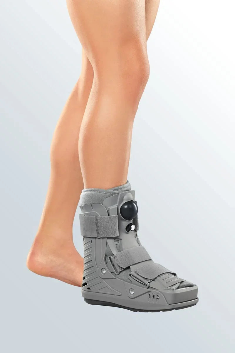 Person wearing a medical walking boot for foot or ankle injury support