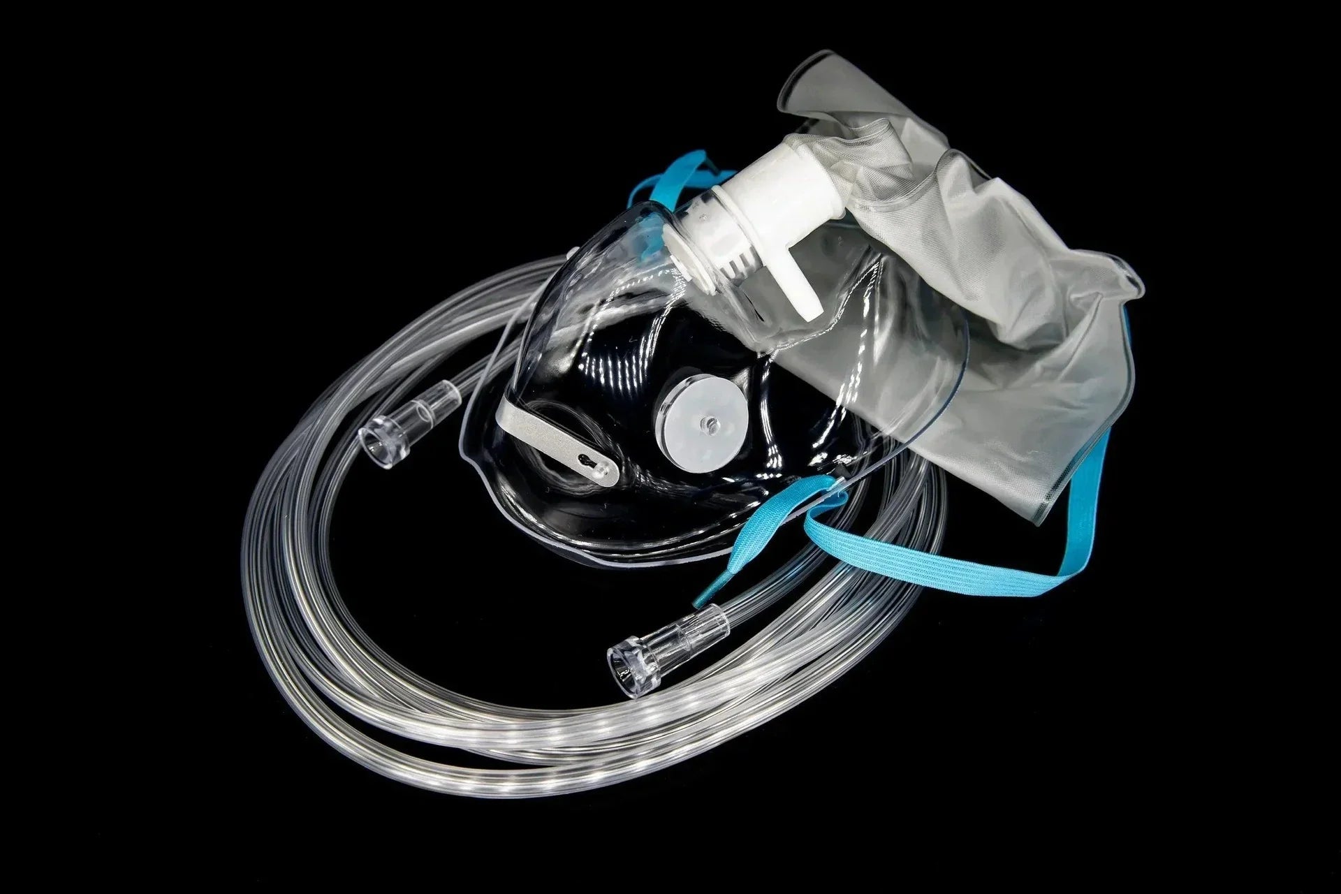 Oxygen mask with tubing and reservoir bag for respiratory care on black background
