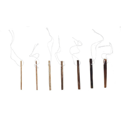 Set of seven assorted wooden tongue depressors with attached white strings on white background