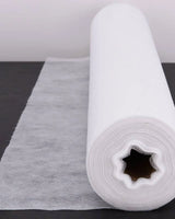 White disposable bed sheet roll for medical or spa use on dark surface
