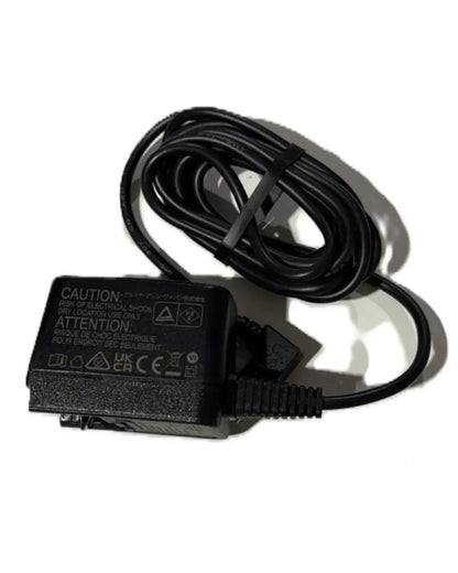 Black medical device power adapter with coiled cable on white background