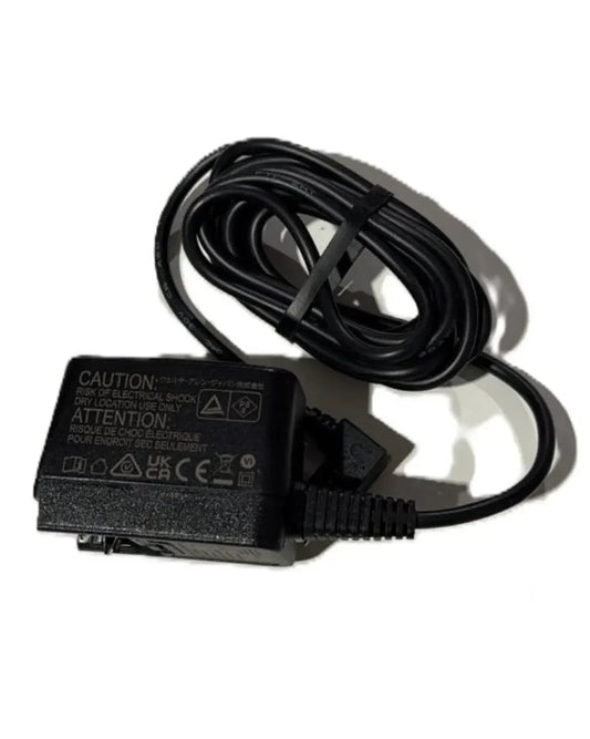 Black medical device power adapter with coiled cable on white background