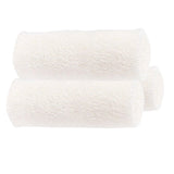 Three white medical gauze rolls for wound care and first aid supplies