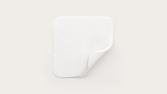 White rectangular medical absorbent pad with rounded corners and textured underside