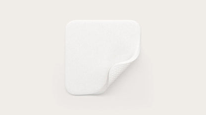 White rectangular medical foam dressing pad with rounded corners and textured underside