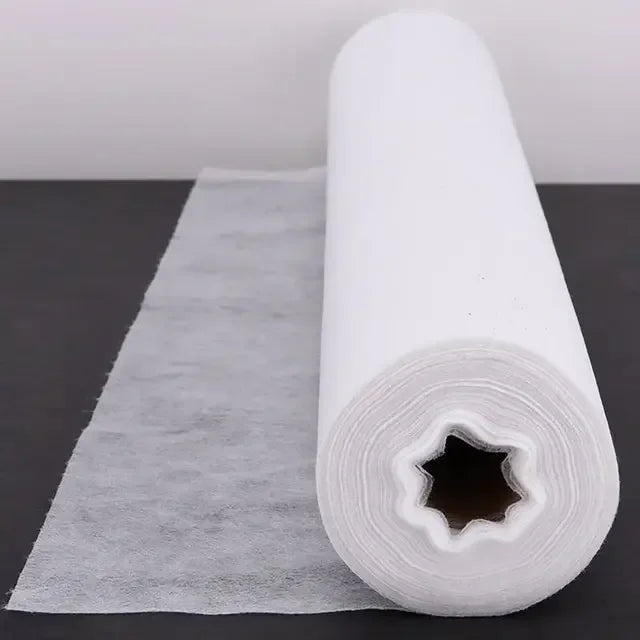 White disposable bed sheet roll for medical and esthetic use on black surface