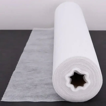 White disposable bed sheet roll for medical and esthetic use on black surface