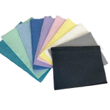 Assorted disposable dental bibs in multiple colors, ideal for medical and home care use