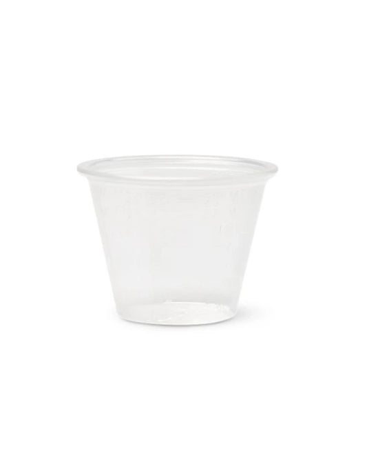 Clear plastic medicine cup for dosage measurement on white background