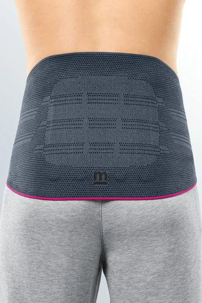Person wearing a gray lumbar back support brace for pain relief and posture correction