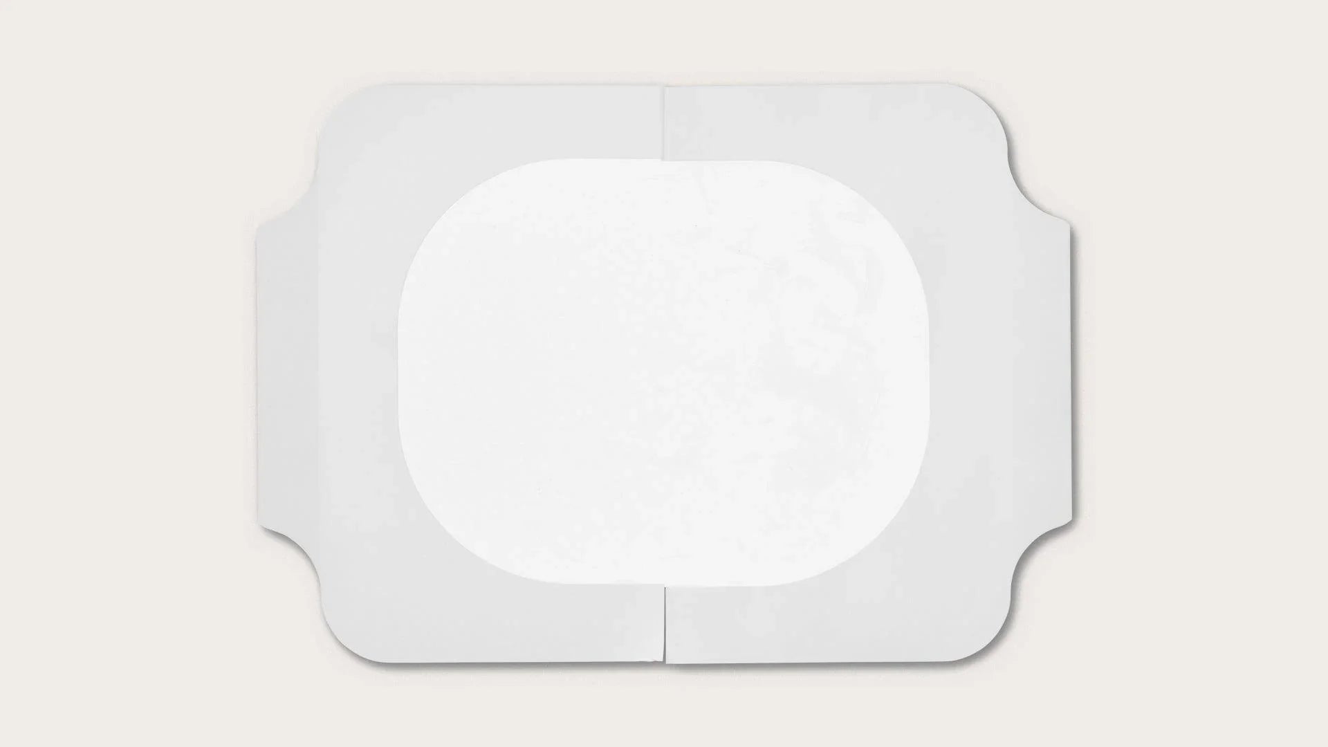 Sterile rectangular medical adhesive dressing with central absorbent pad on white background