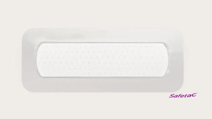 Rectangular adhesive wound dressing with soft white absorbent pad, Safetac logo visible.