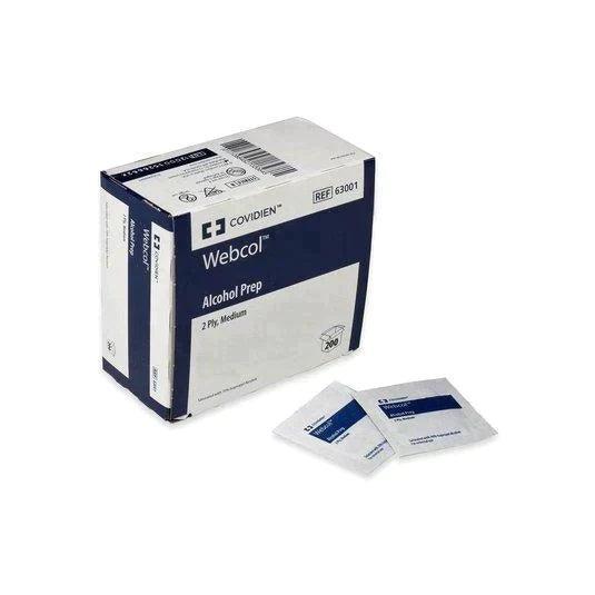Box of Covidien Webcol alcohol prep pads with two individual sterile wipes placed in front.