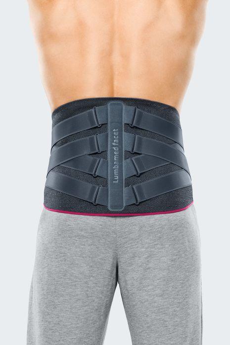 Back view of a person wearing a gray lumbar support brace for back pain relief