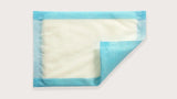 Disposable underpad with blue edges, absorbent medical bed protector on white background