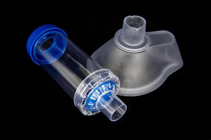 Spacer chamber and silicone face mask for inhaler, respiratory medical device on black background.