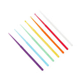 Set of seven colorful plastic medical comedone extractors arranged in a row on white background