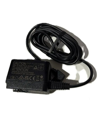 Black medical device power adapter with coiled cable on white background