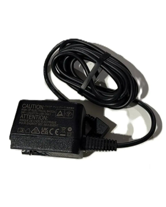 Black medical device power adapter with coiled cable on white background