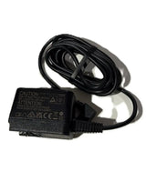 Black power adapter with coiled cable, medical equipment charger on white background