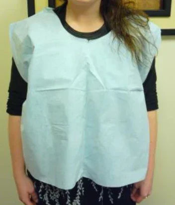 Person wearing disposable medical bib for home care or esthetic use