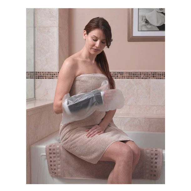 Woman sitting in a bathroom using waterproof cast and bandage cover on arm
