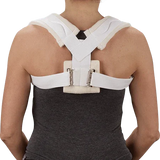 Person wearing a white clavicle brace posture corrector on back, home medical support