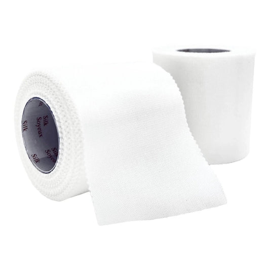 Two rolls of white medical silk adhesive tape, one partially unrolled, on a white background