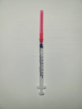 Medical syringe with clear barrel and red needle cap on white background