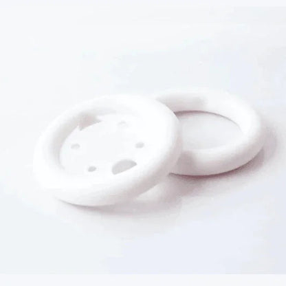 White foam circular medical dressing pads with ventilation holes on white background