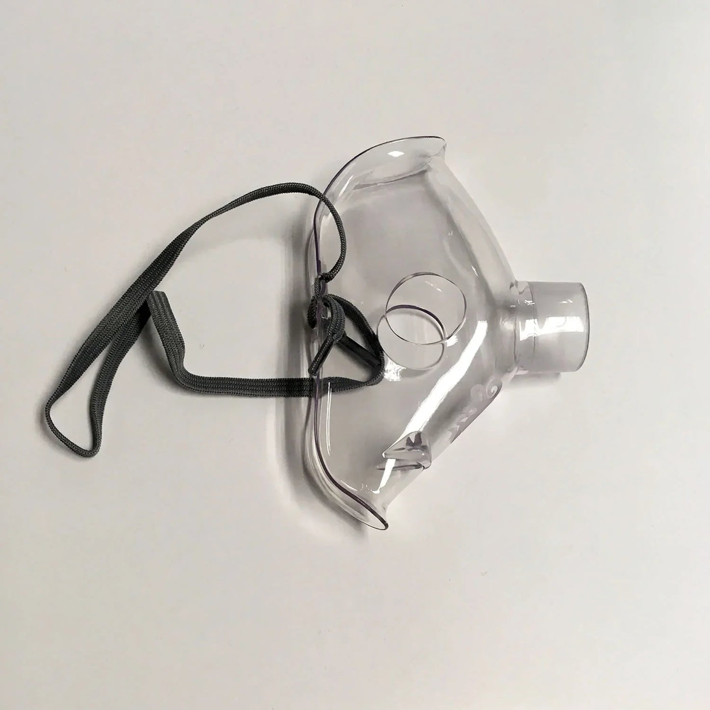 Clear plastic oxygen mask with elastic strap for respiratory care on white background