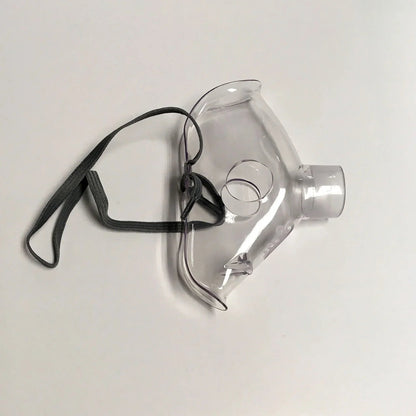 Clear plastic oxygen mask with elastic strap for respiratory care on white background