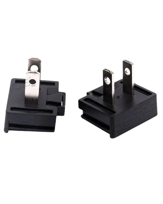 Close-up of two black electrical plug adapters with metal prongs for home medical equipment