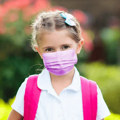 Young girl wearing a pink ASTM level 3 kids face mask and backpack outdoors