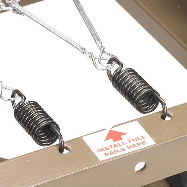 Close-up of hospital bed frame with metal springs and install rails instruction label.