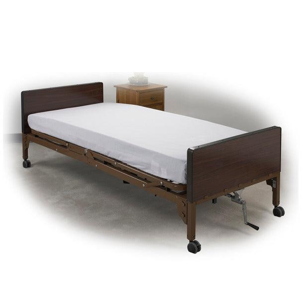 Fitted white medical bed sheet on hospital bed with wooden headboard and caster wheels