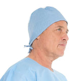 Man wearing a disposable blue surgical cap and medical gown, side profile view