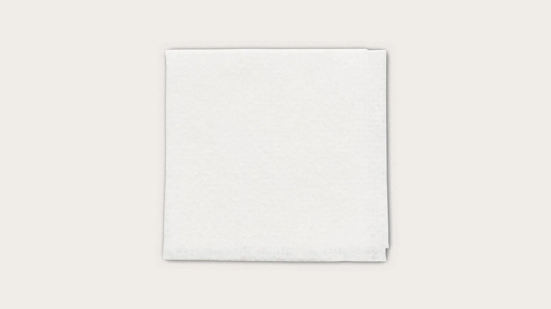 Stack of white sterile medical gauze pads on a plain background