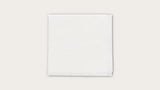 Sterile white medical gauze pad on a plain background