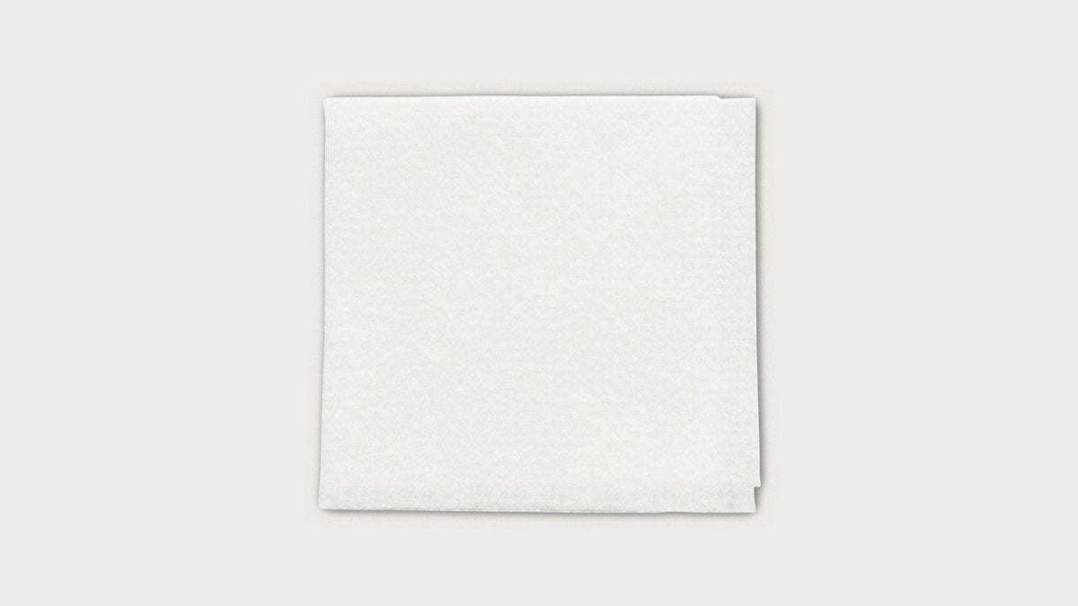 Sterile white medical gauze pad on a plain background for wound care