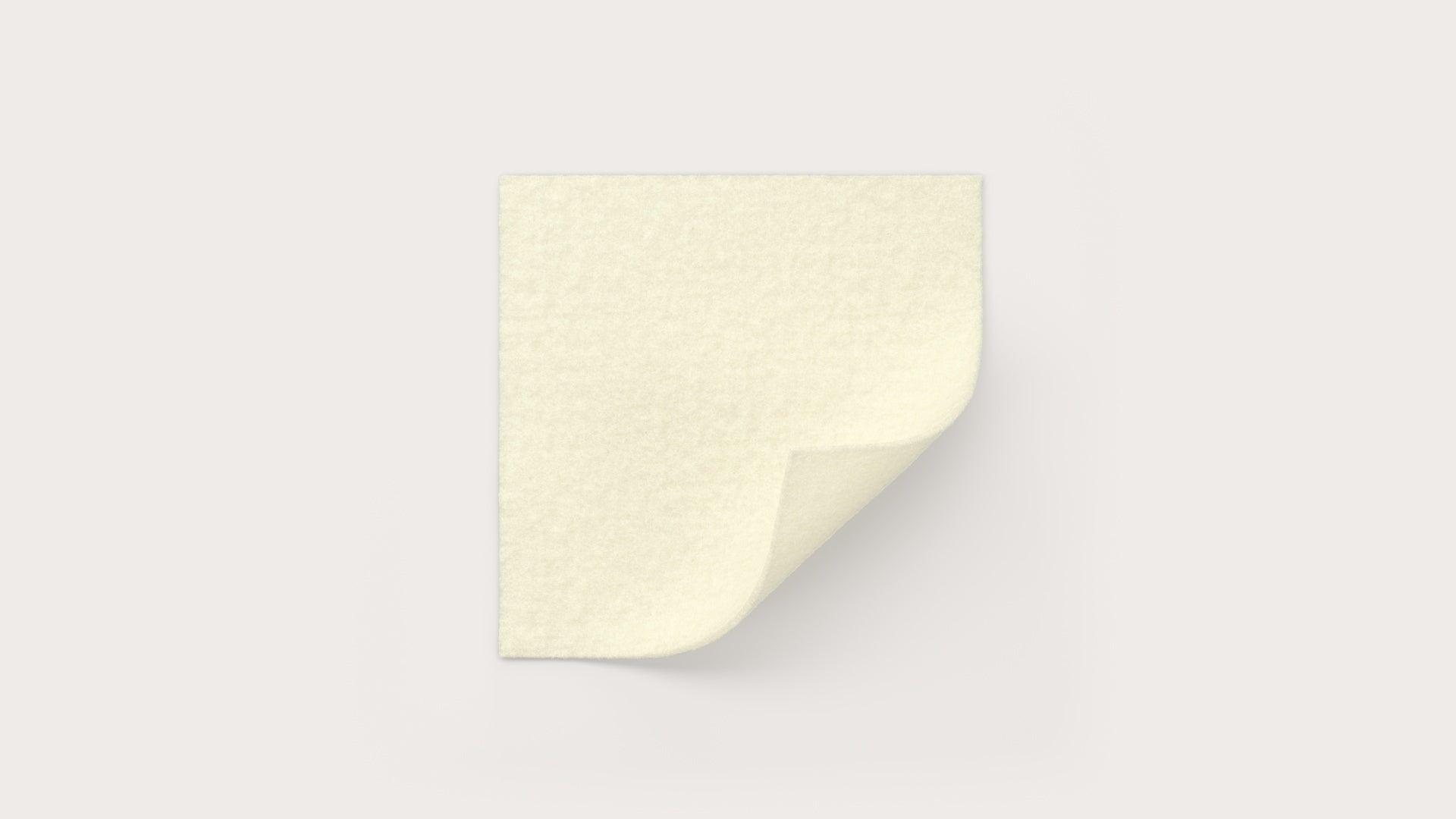 Beige medical gauze pad on white background with corner folded