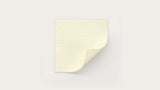 Square hydrocolloid wound dressing with a peeled corner on a plain background