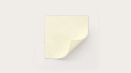 Sterile adhesive medical dressing pad with a folded corner on a plain background